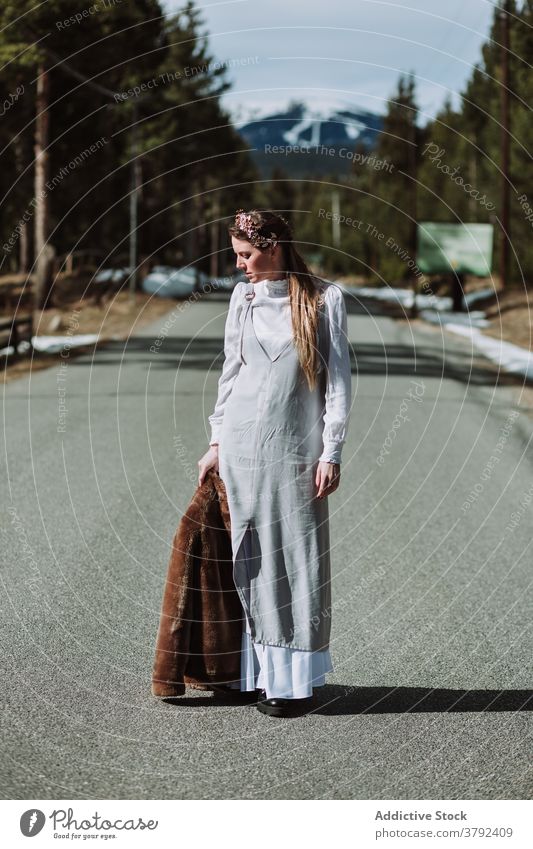 Pensive woman in white maxi dress standing on rural road pensive thoughtful charming style nature gorgeous route serene grace harmony trendy alley daytime