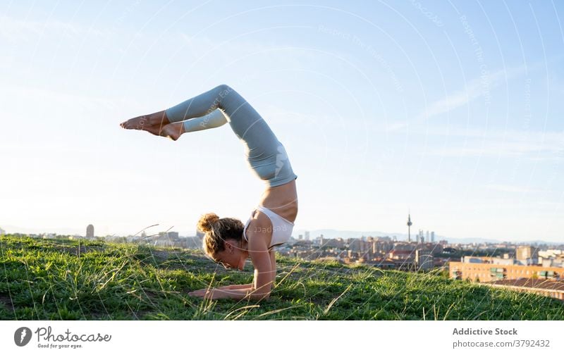 Unrecognizable strong woman balancing on headstand pose on hilltop yoga upside down balance tranquil outstretch advanced asana wellbeing zen serene wellness