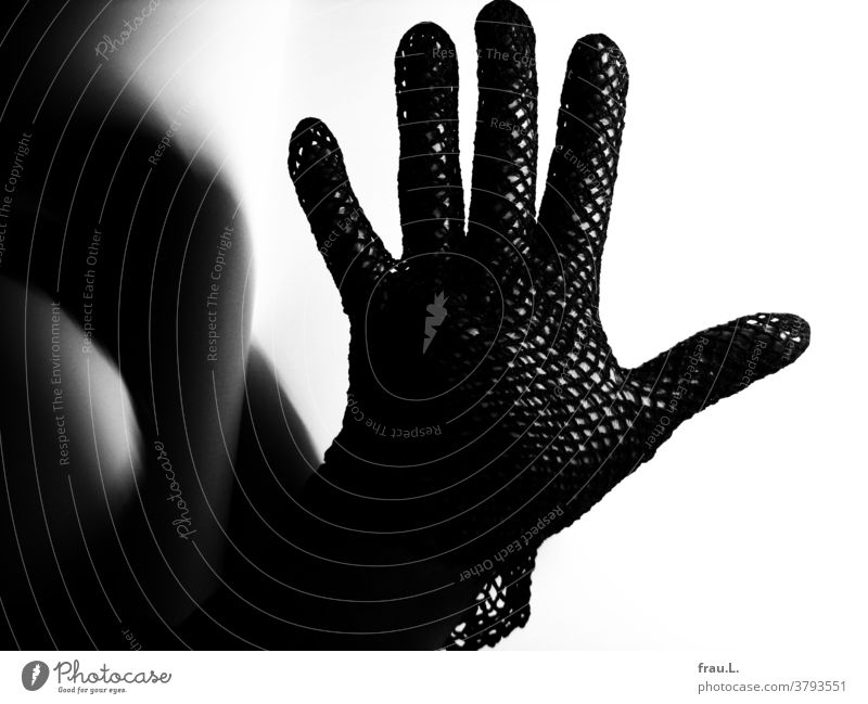 Lonely mesh glove on lonely woman's hand. Shadow Woman Fingers Black Skin