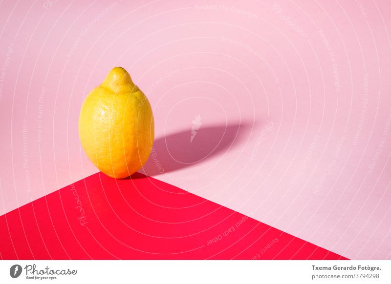 Isolated lemon projecting shadow on red and pink background color yellow saturated still life minimalism fruit isolated natural acid concept horizontal texture