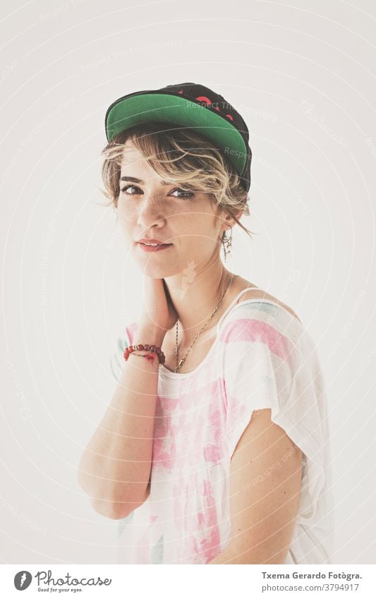 Natural portrait of girl with hat on neutral background natural shirt unfiltered expression european caucasian woman looking at camera young adult vintage tone