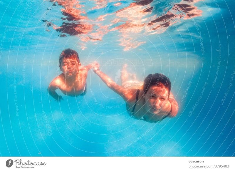 Mother and son diving on a swimming pool action active activity aqua baby beautiful blue boy child children daughter dive diver emotion enjoy family fun funny