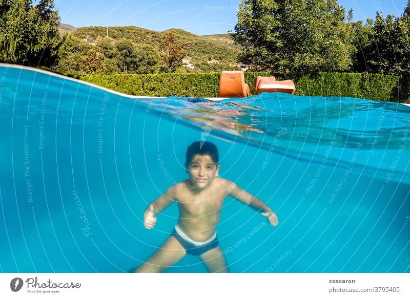 Funny boy diving on a swimming pool active aquatic blue caucasian cheerful child childhood clear cute dive dome enjoy enjoying enjoyment excited expressions