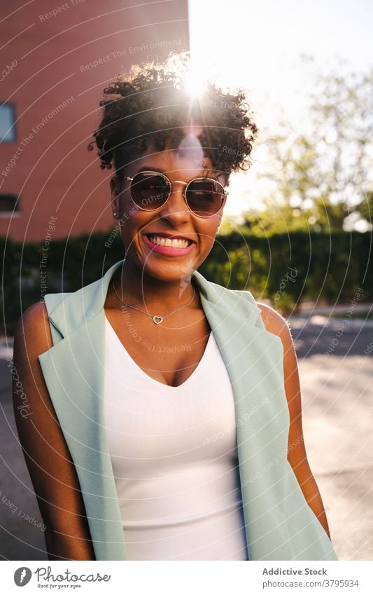 Stylish ethnic woman in sunglasses standing near fence style trendy happy summer afro smile cheerful young female african american black positive relax casual