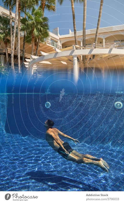 Unrecognizable person diving into swimming pool dive underwater summer resort holiday refreshment tropical activity splash transparent vacation travel