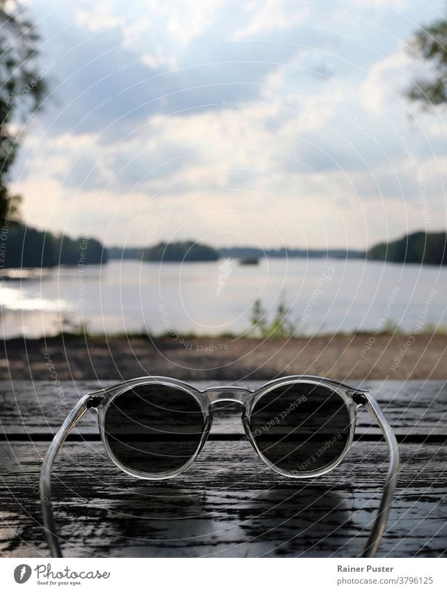 Beautiful lake seen behind a pair of sunglasses accessory background copy space eyeglasses looking through sunglasses personal perspective point of view pov