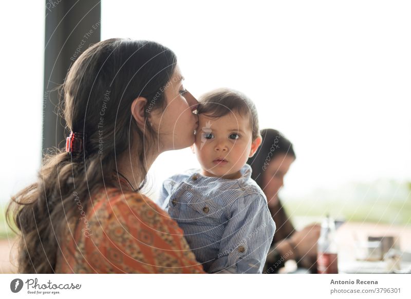 mother kissing little baby at bar terrace mother's day son restaurant love lifestyles people women woman kid child children boy care parent mothers day spanish