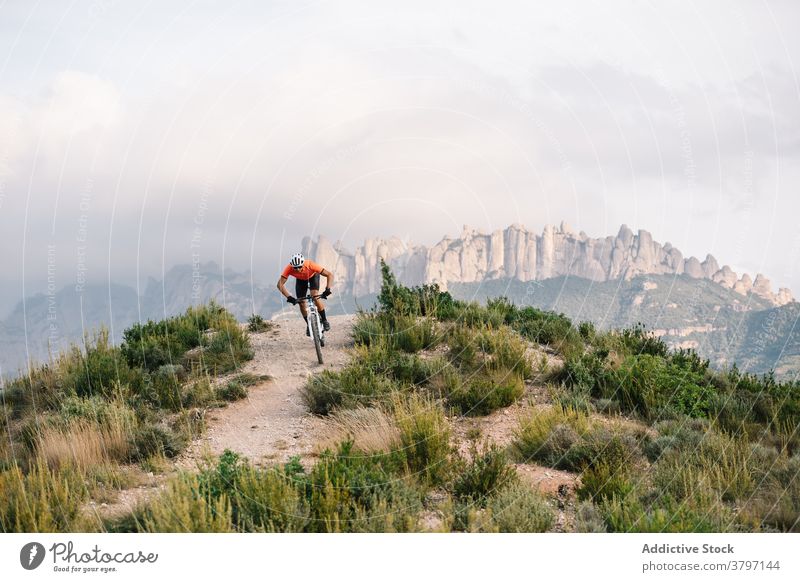 Active man with bicycle in hilly terrain cyclist mountain bike active sport ride nature male helmet adventure transport travel extreme freedom vehicle lifestyle