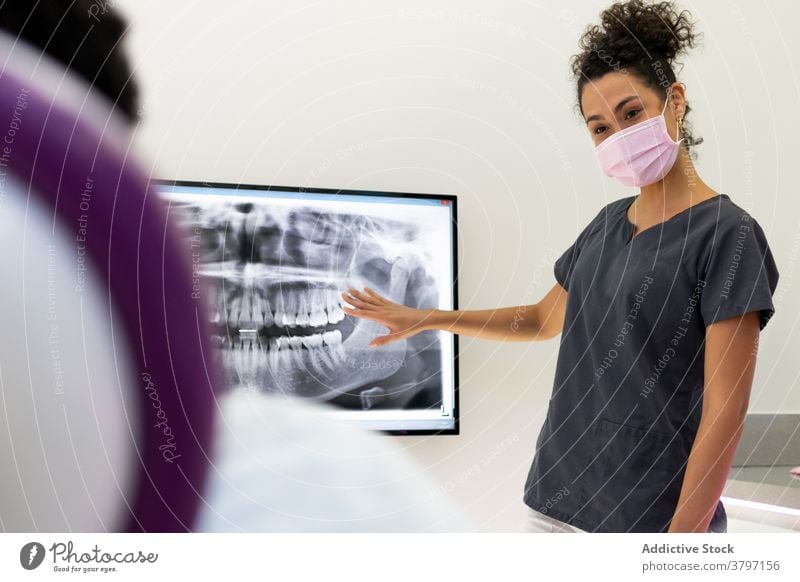 Ethnic female dentist in medical room with X ray x ray dental clinic doctor woman dentistry teeth patient jaw ethnic black african american uniform mask
