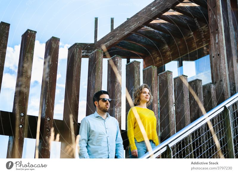 Serious couple standing on bridge style trendy unemotional grunge apparel outfit summer construction stair stairway staircase step young together relationship
