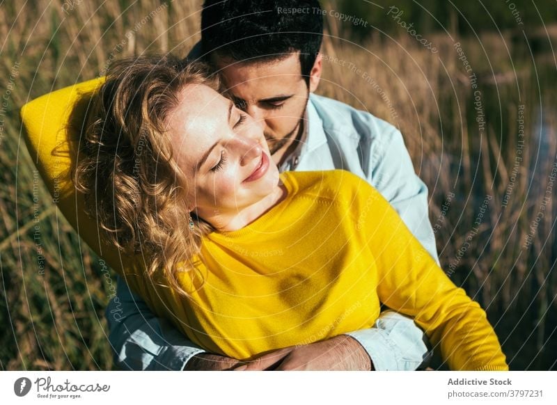 Happy couple embracing gently in nature hug love tender embrace field sunny summer relationship eyes closed girlfriend calm boyfriend together affection happy