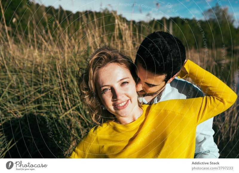 Happy couple embracing gently in nature hug love tender embrace field sunny summer relationship eyes closed girlfriend calm boyfriend together affection happy