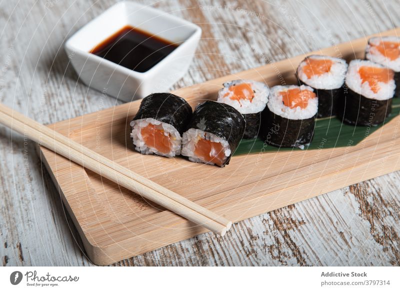Sushi rolls with salmon on wooden board sushi hosomaki japanese food seafood fish tradition set fresh meal cuisine dish gourmet oriental asian chopstick serve