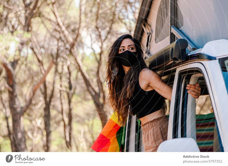 Woman coming out of van in forest picnic woman weekend coronavirus pandemic woods relax holiday safety summer enjoy daytime adventure protect nature mask