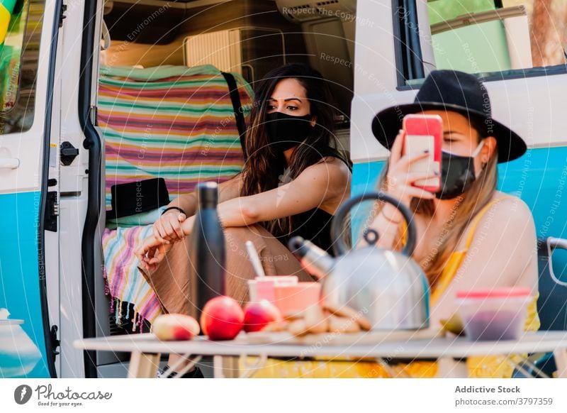 Women relaxing in van in summer picnic women friend together coronavirus mask protect friendship nature weekend holiday sit rest epidemic calm young enjoy