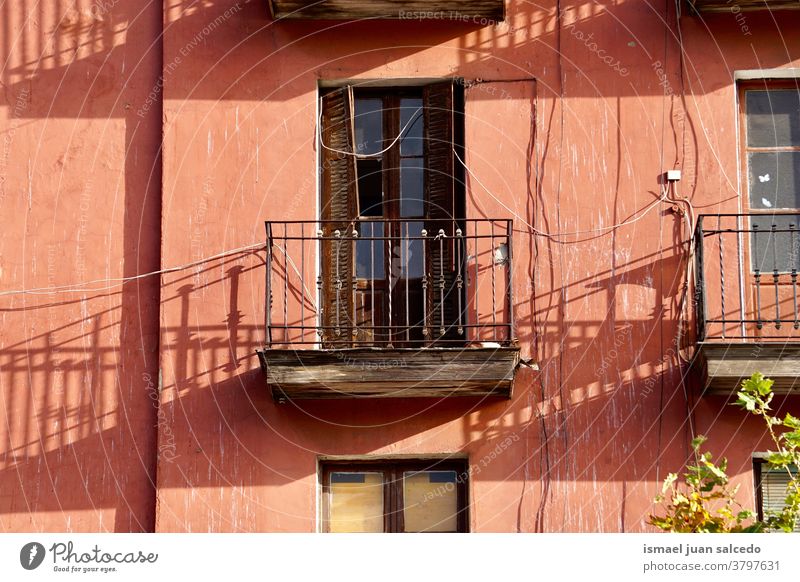 balcony and window on the red facade of the house fence building exterior home street city outdoors color colorful structure architecture construction wall