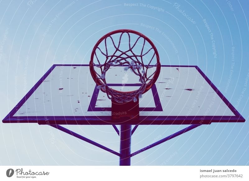 street basketball hoop  and blue sky silhouette circle chain metallic net sport sports equipment play playing playful old park playground outdoors minimal