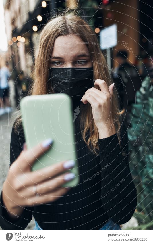 Young woman having video call talking while walking downtown wearing the face mask to avoid virus infection care caucasian chat contagious corona coronavirus