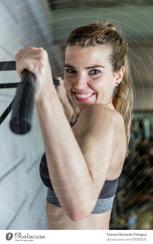 Young happy woman working her arms muscles in the Gym fitness exercise sport active lifestyle gym gymnasium female healthy indoors training beautiful intense