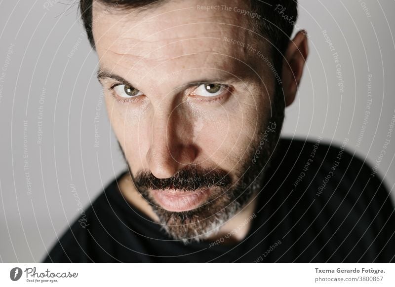 Close-up portrait of a bearded middle-aged man against neutral background studio confident grey guy face isolated adult lifestyle cool indoors mature close-up