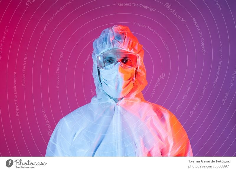 Portrait of man with chemical protective equipment for covid-19 against colored background mask protection coronavirus safety disinfection disease doctor