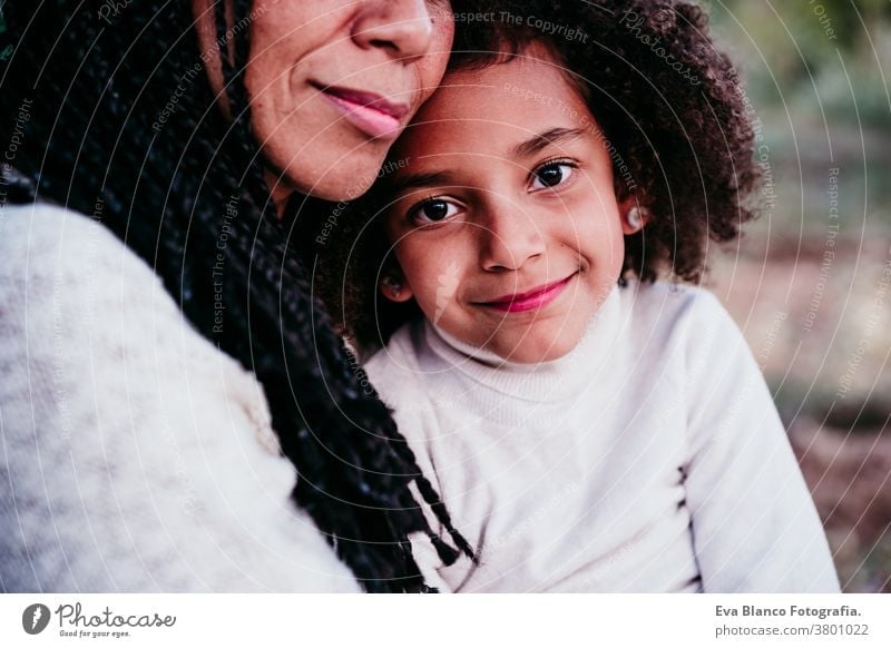 v portrait mother daughter family outdoors mixed race hispanic afro motherhood childhood parenthood single mother autumn nature park hug cheerful togetherness