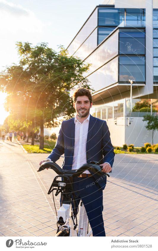 Stylish man in suit walking on pavement with electric bike stylish apparel fashion commute street masculine formal wear style modern creative design vehicle