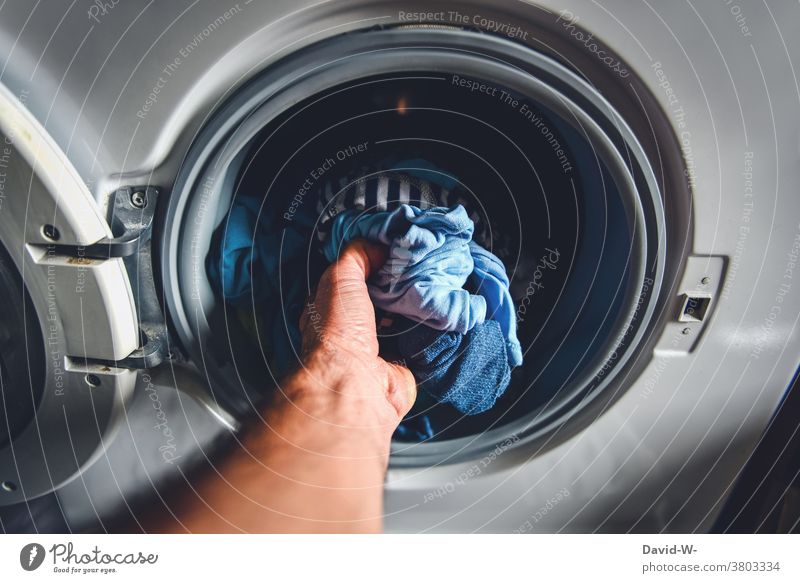 Man does laundry and reaches into the washing machine Wash Washer Househusband neat Washing day Housekeeping Photos of everyday life Living or residing Hand