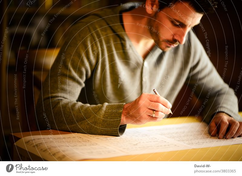 Man writes notes Musician musical concentrated Arrange Artist study Composer Write Pencil