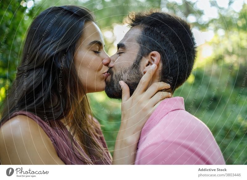 Loving ethnic couple kissing in sunny park sensual eyes closed in love relationship passion lover amorous temptation affection fondness amour tender valentine