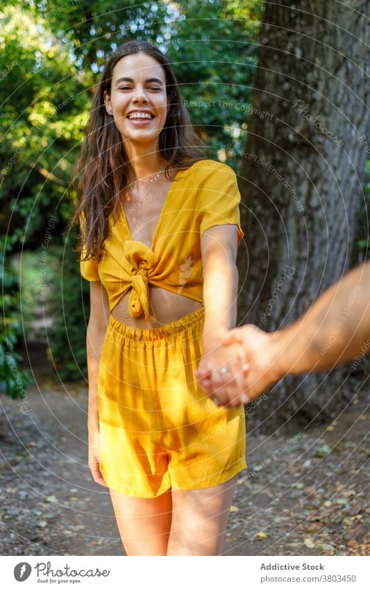 Happy ethnic woman spending time in park with anonymous boyfriend during summer vacation holding hands cheerful happy holiday couple relationship together love