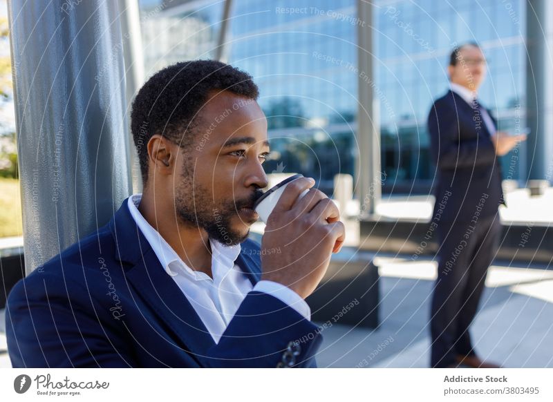 Young black businessman drinking coffee to go on street during break takeaway focus rest entrepreneur coffee break style confident modern male young
