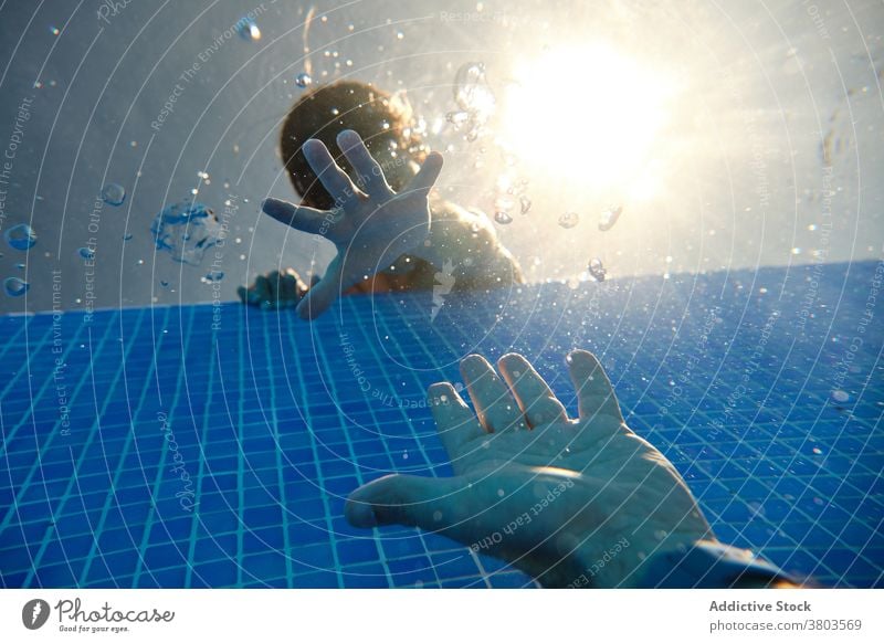 Boys hand reaching for going under pool water man boy help sink underwater danger rescue save suffocate support last problem trouble lifesaver emergency aqua
