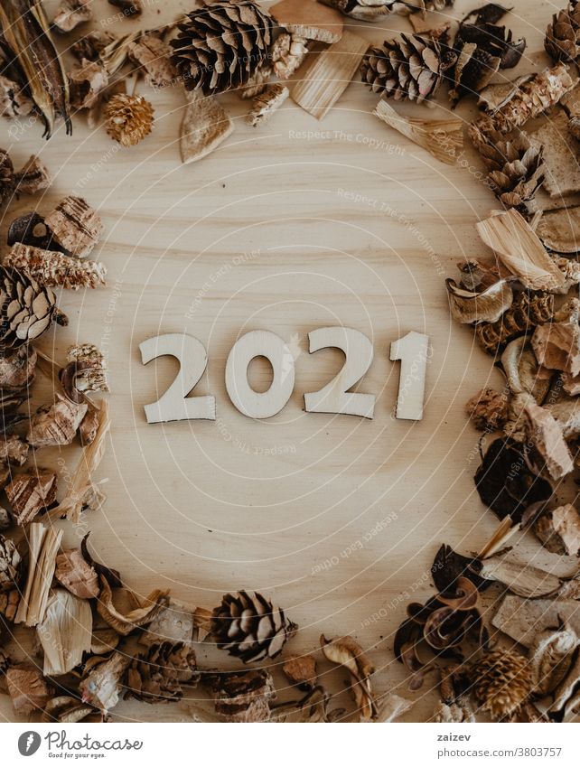 2021 in wooden numbers to celebrate the new year without people indoor close up copy space center portrait vertical monochrome table fruit dry dried pineapples