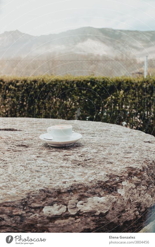 Morning cup of coffee on a old stone table with mountain background at sunrise hot cafe white steam landscape mug morning closeup drink breakfast warm healthy