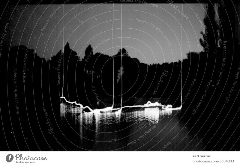 At night at Lake Wolf in Borki Evening Night Dark darkness Light shoulder stand Illumination Water Surface of water Pond Body of water blurred Skewed
