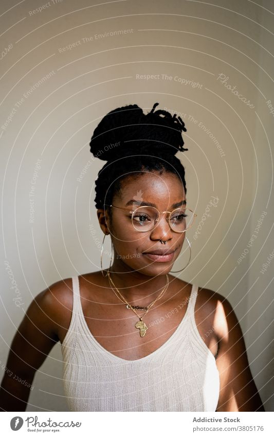 Black woman in eyeglasses in room toothy smile hairstyle accessory fashion outfit content cheerful female african american black happy brunette joy positive
