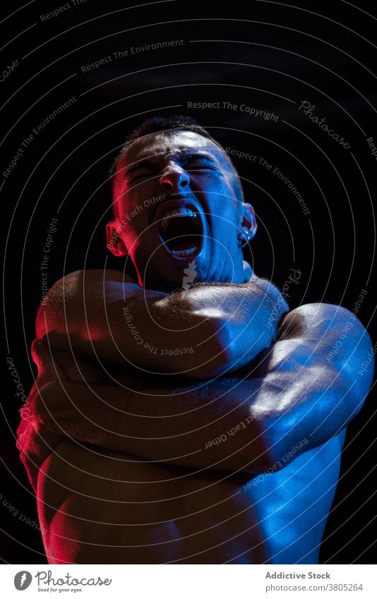 Man shouting while covering chest and neck with crossed arms man scream despair depression unhappy stress problem cry trouble male aggressive sporty muscular