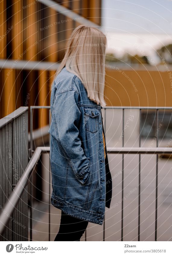 Junge blonde Frau im Profil im urbanen Raum jeansjacke lange haare lifestyle portrait hübsch schön woman glücklich erholung zufriedenheit lachen lächeln