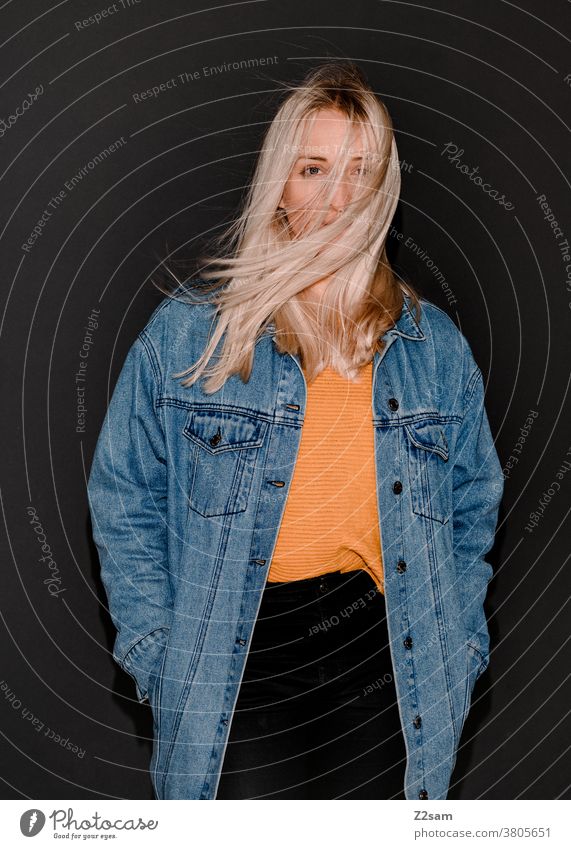 Fashion-Portraits einer jungen Frau blonde flashlook jeansjacke paparazzi-look trashig mode pullover lange haare hübsch wind wehen portrait beautiful lifestyle