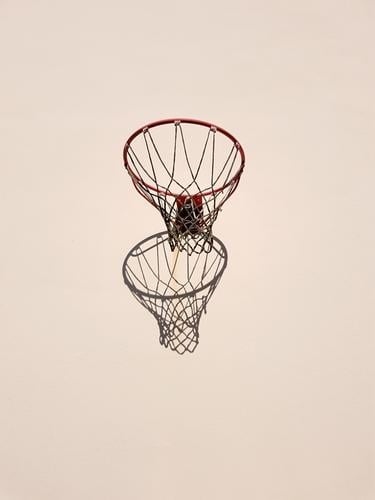 Basketball hoop and its shadow on a light-coloured house wall Basketball basket Shadow Sports Athletic Leisure and hobbies Copy Space top Copy Space bottom