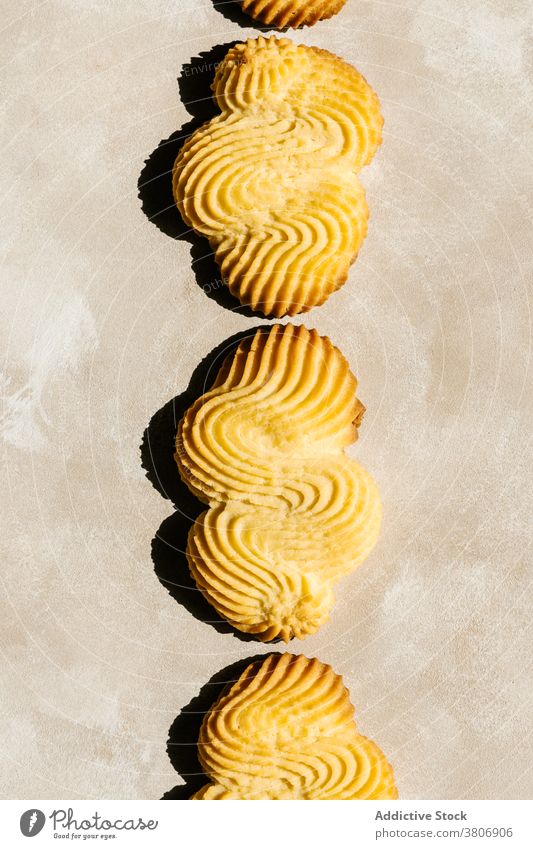 Bright golden baked biscuits with ornament on table treat pastry delicious sweet creative design background decorative colorful yummy natural organic product