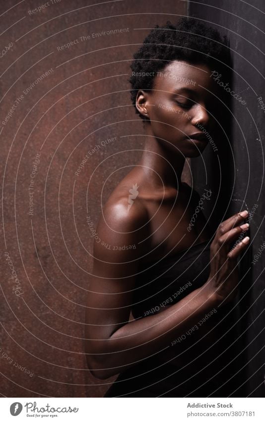 Alluring black woman standing in dark studio model seductive allure grace slender feminine temptation sensual vogue appearance fit beautiful attractive
