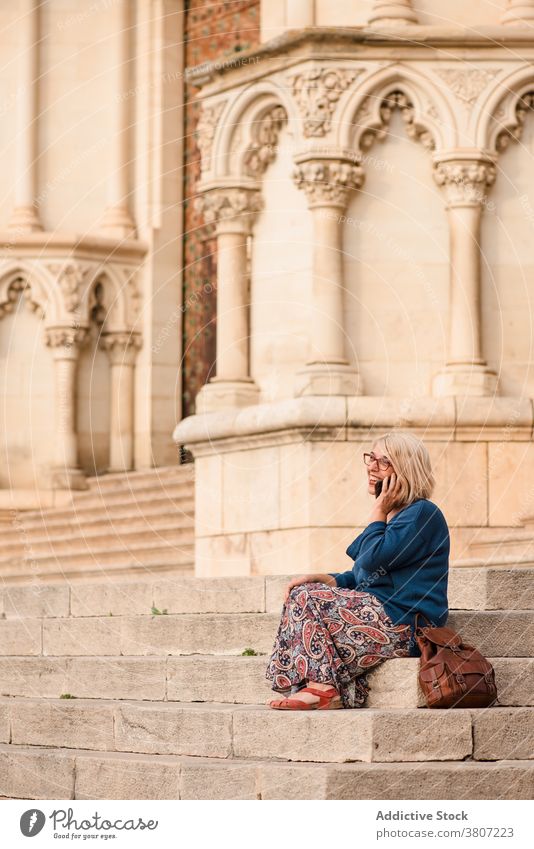 Traveling woman in mask talking on phone near ancient building traveler smartphone medieval historic stair town coronavirus architecture sightseeing visit call
