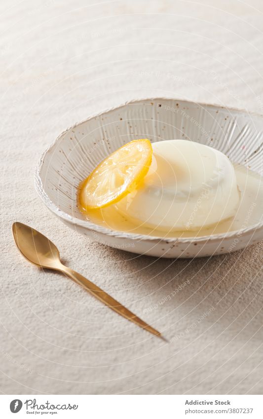 Tasty panna cotta with orange slice in bowl jam dessert sweet treat yummy spoon table bright confiture tasty portion delicious appetizing natural dairy product