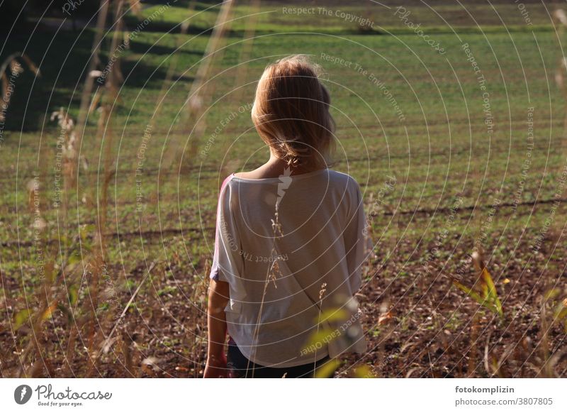 Girl looking at a fresh green field acre spring Growth Wait Arable land back view Back Field Landscape Agriculture Spring Spring fever Sprout wax Nature