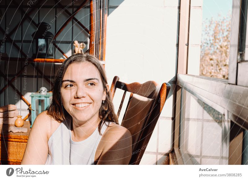 Young woman in vintage clothes sitting at a window with a bright day and smiling with copy room and colorful Woman person Smiling Caucasian Home Curtain Blind