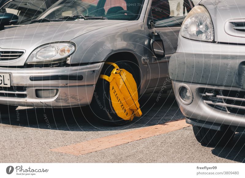 Clamp on the wheel of a car stocks infringement parking clamp boot stuck fine vehicle clamped white tyre parked restricted wrong breach locked city block