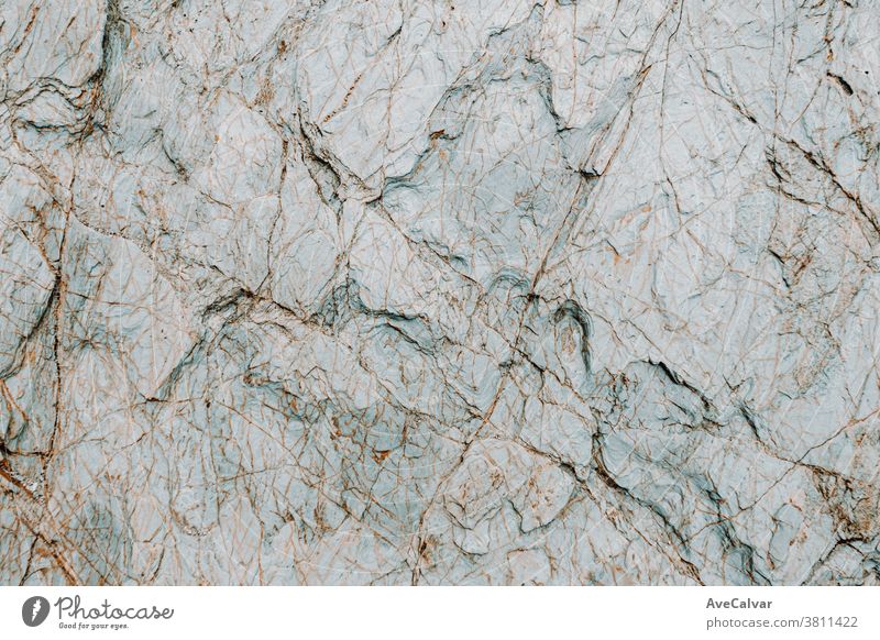 Flat background of a white with blue tones rock with rocky texture textured rough surface grunge up marble horizontal structure close up distressed hard layer