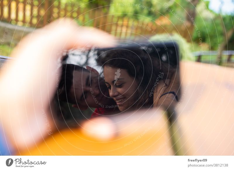 Couple kissing on the reflection of a phone couple love smartphone